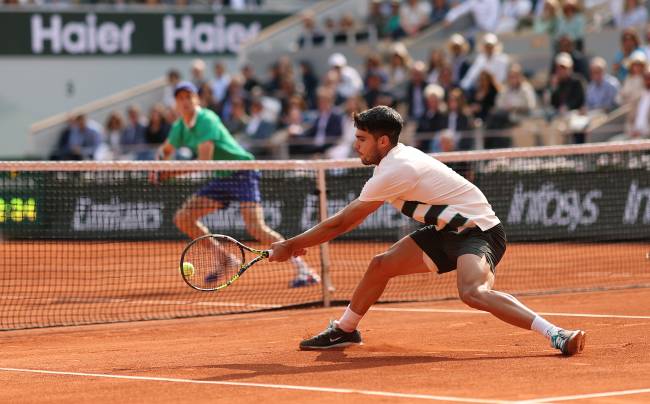 PARIS, FRANCE - JUNE 08: Carlos Alcaraz of Spain plays a backhand at the net against against Jannik Sinner of Italy during the Men's Singles Final match on Day Fifteen of the 2025 French Open at Roland Garros on June 08, 2025 in Paris, France. (Photo by Clive Brunskill/Getty Images)